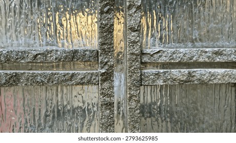 Close up of granite stone window frame with textured wavy glass panels, architectural background texture