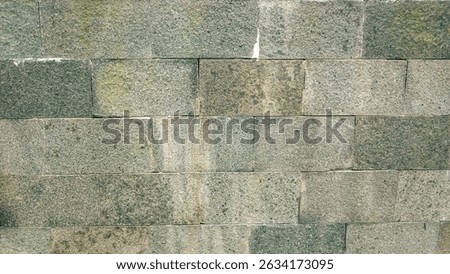 Close up of gray stone wall. Suitable for backgrounds, textures, construction materials, architectural elements, and urban design projects focused on stone structures and textures.