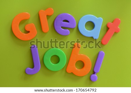Close up of Great Job! words in colorful plastic letters on green background