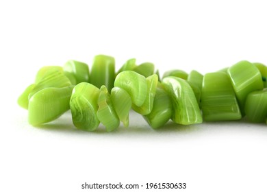 Close up of green Beads on the white background, unshaped beads, Background or texture of beads. macro,used in finishing fashion clothes. make bead necklace or string of beads for woman of fashion.
