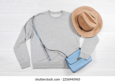 Close up grey blank template sweatshirt hoodie with copy space. Top view mockup pullover on white wooden background. Casual outfit. Flat lay template clothes. Woman accessories - Shutterstock ID 2256945965