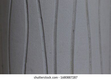Close up of a grey surface with irregular lines cut into the material