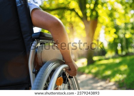 Close up of a gril sit in wheelchair during walk in park with copy space, young disabled teenager in  carriage or wheel chair, young disability concept image