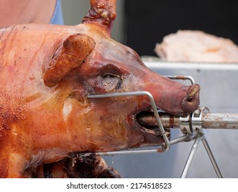 Close up of a grilled suckling pig on a spit
