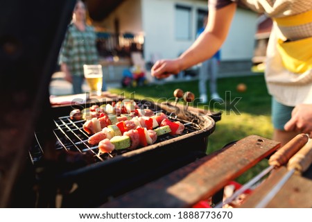 Close up of grilled vegetables and meat on sticks on grill. Family gathering concept.