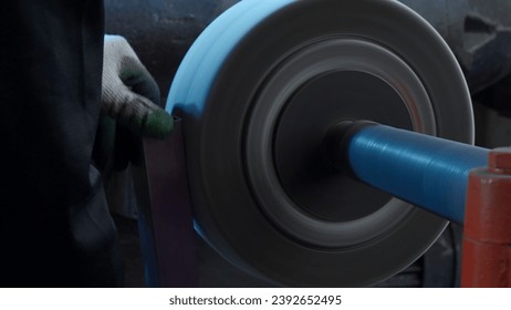 Close up of grinding machine with spinning fast polishing disk. Creative. Metal details production on factory. Manufacturing, industrial and technology concept. - Powered by Shutterstock