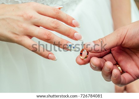 Close up Groom Put the Wedding Ring on bridethe bride puts on an engagement ring on the groom's finger