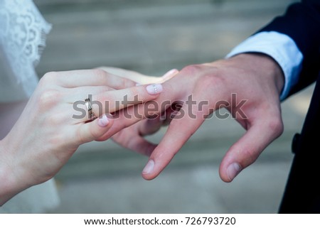Close up Groom Put the Wedding Ring on bridethe bride puts on an engagement ring on the groom's finger