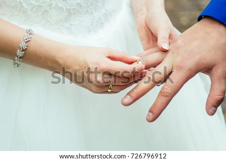 Close up Groom Put the Wedding Ring on bridethe bride puts on an engagement ring on the groom's finger