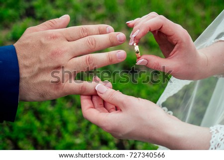 Close up Groom Put the Wedding Ring on bridethe bride puts on an engagement ring on the groom's finger