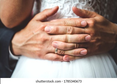 Close up of groom's palms with wedding ring embracing bride. - Shutterstock ID 1785340673