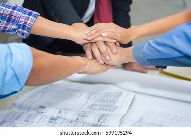 Close up group of Asian Construction engineer,worker,Asian foreman and owner  shake up their hand after achieve their mission or construction.