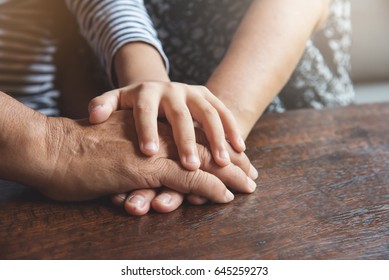 Close up of Group of Asian Elderly and kid join hands or stacking on old wood table together. Teamwork, Partnership, support, unity, Power of family team concept. - Shutterstock ID 645259273