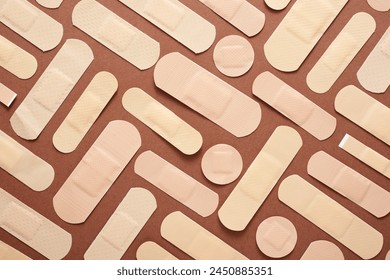 Close up of a group of first-aid plasters on a brown surface