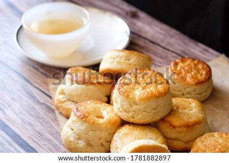 Close up group of fresh yummy tasty delicious Traditional British Scones and a cup of tea on wooden table  background. 