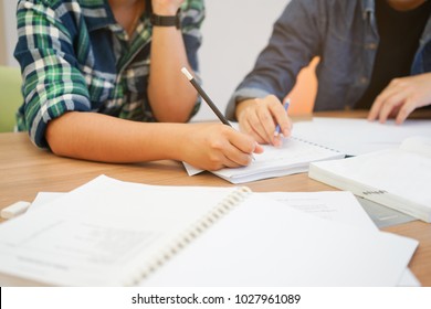 Close Up Group Of People : Girl Hand Writing Something On Text Book And Teaching Her Friend About Calculus Subject In Library Private Room For Test Examination , Education Concept