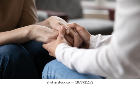 Close up grownup daughter holding mature mother hands, expressing support and care, granddaughter caregiver comforting older grandmother, good trusted family relationship, two generations bonding - Shutterstock ID 1878921172