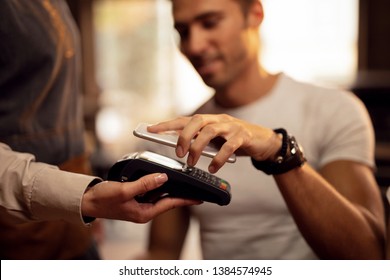 Close Up Of Guest Using Smart Phone While Making Contactless Payment In A Pub. 