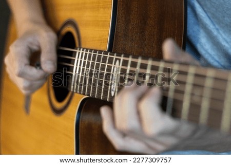 Close up of guitarist playing a acoustic guitar