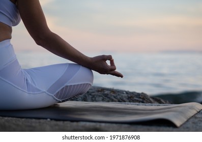 Close Gyan Mudra. Yoga on the beach. Lotus yoga pose. Yogi woman sitting on the sand, meditating, practicing yoga and pranayama with gyan mudra. Sunset time. Yoga lifestyle.