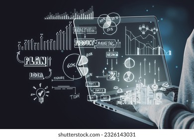 Close up of hacker hands holding and using laptop computer with creative toned business sketch on dark background. Business strategy and finance concept
