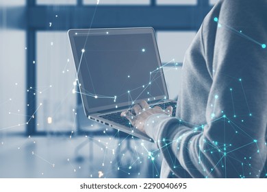 Close up of hacker hands using laptop with glowing polygonal coding mesh on blurry office interior background. Technology and pattern concept. Double exposure