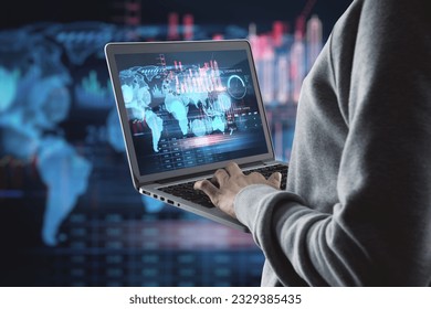 Close up of hacker hands using laptop with creative global forex chart on dark background. Concept of stock market, malware and financial success - Powered by Shutterstock