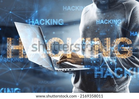Close up of hacker hands using laptop with abstract glowing hacking hologram on blurry office interior background. Hacked device, malware and phishing concept. Double exposure