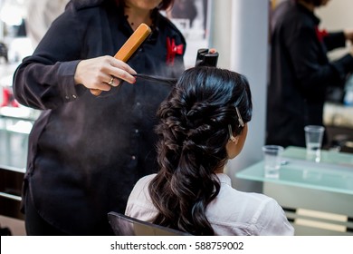 Close Up Of Hair Stylist Making A Braid On Long Brunette Hair In A Beauty Salon. Bridal Hairstyle. Wedding