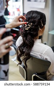 Close Up Of Hair Stylist Making A Braid On Long Brunette Hair In A Beauty Salon. Bridal Hairstyle. Wedding