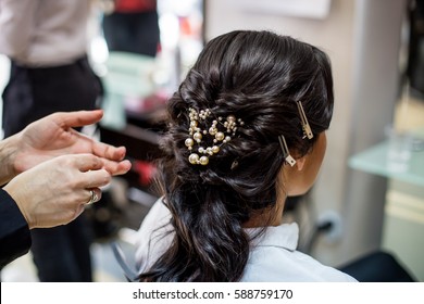 Close Up Of Hair Stylist Making A Braid On Long Brunette Hair In A Beauty Salon. Bridal Hairstyle. Wedding