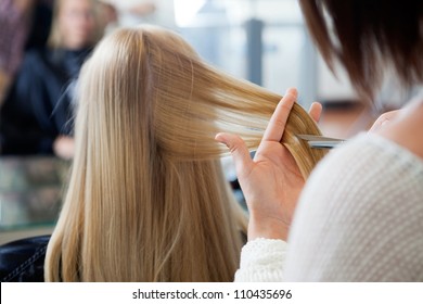 Close Up Of Hairdresser Giving A New Haircut To Female Customer At Parlor