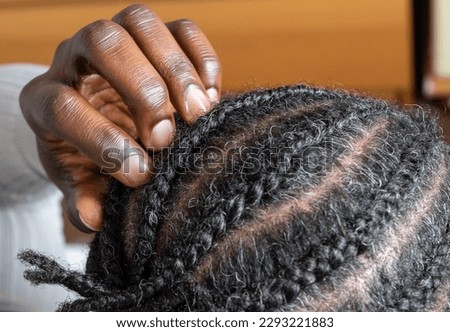 Close up of hairstyle: cornrows on natural black hair. Close up African braided hair of afro American male client in the barber salon. Texture of braided hair on the man's head close-up. grey hair 商業照片 © 