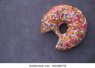 Close Up Of Half Bite On Donut On Table 