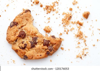 Close up of an half eaten cookie with crumb against a white background