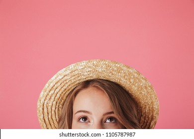 Close Up Half Face Portrait Of A Happy Young Woman In Straw Hat Looking Up Isolated Over Pink Background