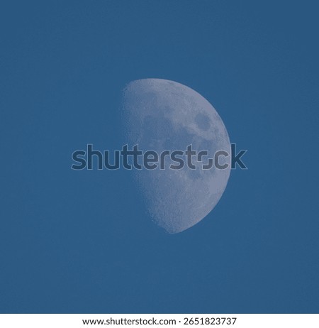 A close up of half moon during daylight with blue sky background