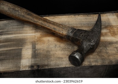 close up of hammer on wood background with reduced vibrance, grungy, old, antique, vintage