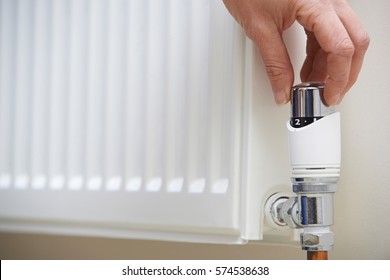 Close Up Of Hand Adjusting Heating Thermostat - Shutterstock ID 574538638