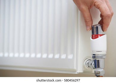 Close Up Of Hand Adjusting Heating Thermostat