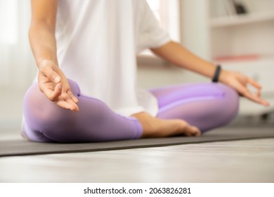 Close up Hand, Asian woman does morning yoga, sitting in Easy position, Sukhasana posture, and meditating.