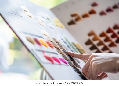 Close Up At Hand Of Asian Women Sitting Inside Hair Salon, Smiling While Choose New Hair Dye Color And Style From The Color Chart Selection. Female Beauty Fashion And Personal Care Concept. 