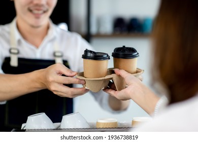 Close up hand. Asian young man or bartender serving paper coffee glass customer at coffee shop. making coffee in cafe. Concept sale paper bag and coffee. maker machine with portafilter - Powered by Shutterstock