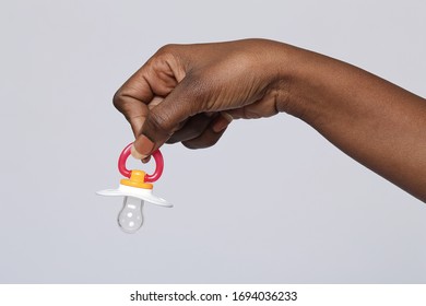 
Close Up Hand Black African Woman Holding A Pacifier On Isolated Studio Background