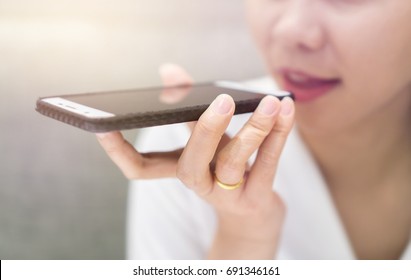 Close Up Of Hand Business Girl Using A Smart Phone Voice Recognition With A Warm Light Background.