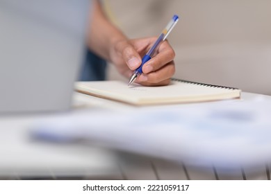 Close Up Hand Of Business Man Holding Pen And Writing To Do List Or Calculated In Book. Writing Work Or Requirment Ideas In Paper On Work Table. Male Hands Holding Pen Making Notes In Notepad