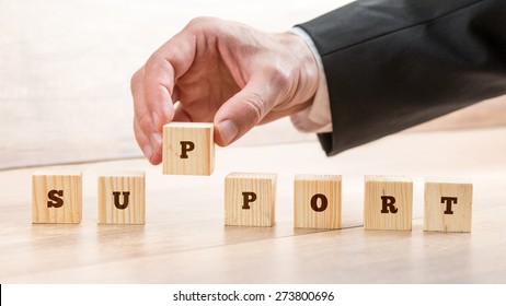 Close up Hand of a Businessman Arranging Small Wooden Blocks on the Table for Business Support and Customer Service Concept.
