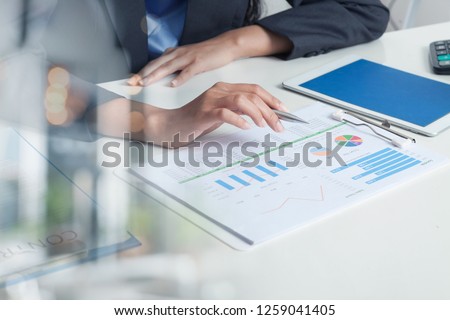 Close UP HAND of  Businesswoman Hold pen and SPREADSHEET Graph Papers on Table. Audit TAX Return on Investment Analysis Shareholders and Capital Market.  Auditor and Analytics, audit,cpa Concepts