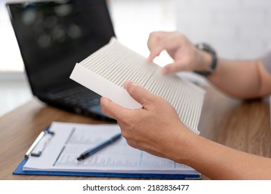 Close Up Hand Car Service Staff Hold Air Filter Of Car Air Conditioning System And Part Quality Check For Service In Car Maintenance And Use Laptop And Checklist On The Wood Table