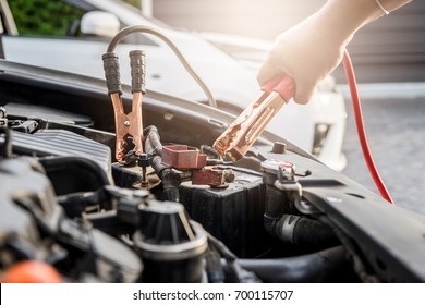 Close up of hand Charging car battery with electricity trough jumper cables